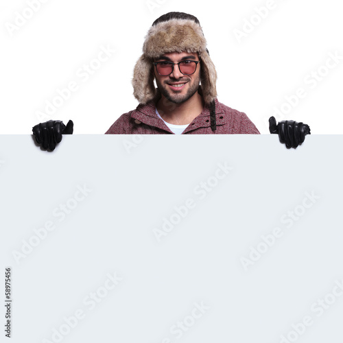 Photo: young man holding a big blank board is smiling young man holding a big blank board is smiling