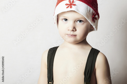 Photo: modest little boy in Santa hat. Christmas. modest little boy in Santa hat. Christmas.