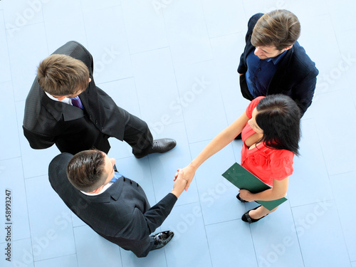 Photo: Full length image of business men shaking hands with each other Full length image of business men shaking hands with each other
