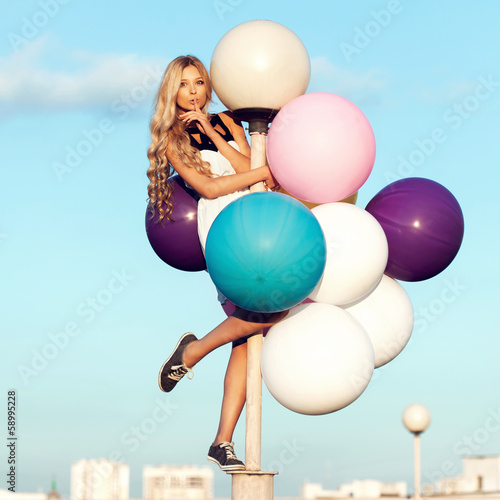 Photo: Happy young woman with colorful latex balloons Happy young woman with colorful latex balloons