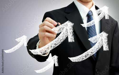 Photo: Businessman with Rising Arrows Representing Growth Businessman with Rising Arrows Representing Growth