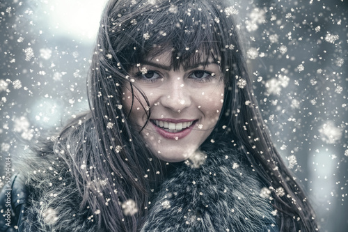 Photo: Smiling young woman in a winter snow day Smiling young woman in a winter snow day