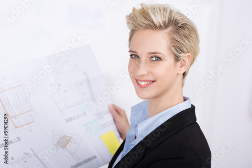 Photo: lächelnde blonde frau mit bauplan lächelnde blonde frau mit bauplan
