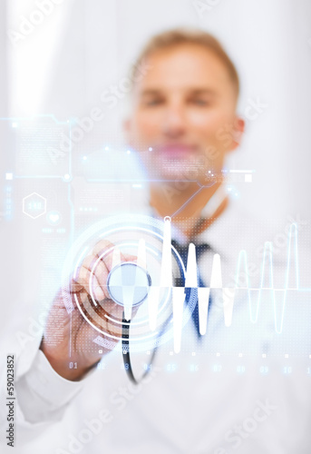 Photo: male doctor with stethoscope and cardiogram male doctor with stethoscope and cardiogram