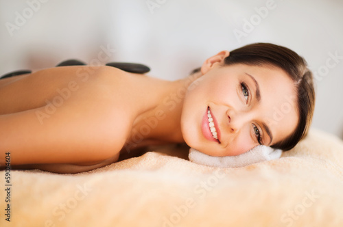 Photo: beautiful woman in spa salon with hot stones beautiful woman in spa salon with hot stones