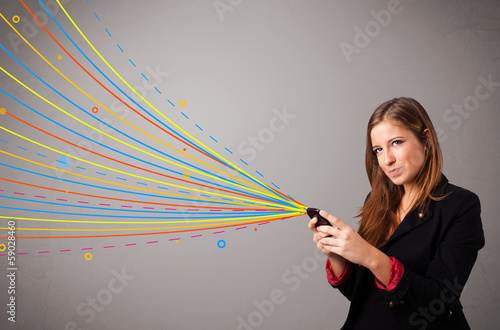 Photo: Happy girl holding a phone with colorful abstract lines Happy girl holding a phone with colorful abstract lines