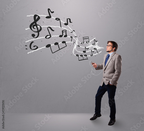 Photo: handsome boy singing and listening to music with musical notes handsome boy singing and listening to music with musical notes