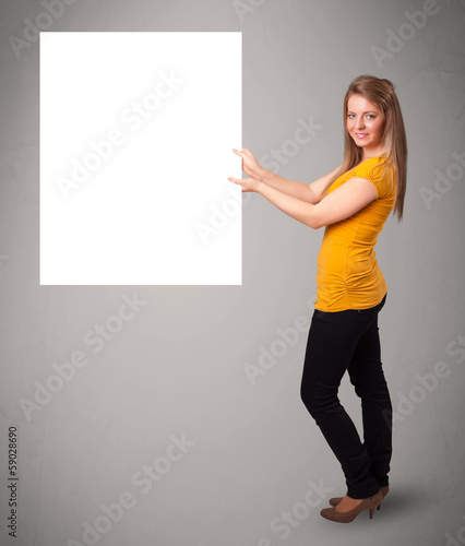 Photo: Young woman presenting white paper copy space Young woman presenting white paper copy space