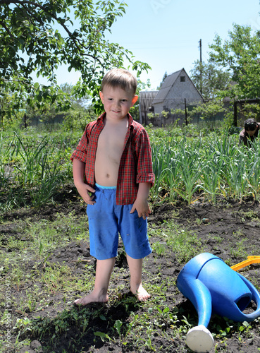 Photo: Happy little boy working in the garden Happy little boy working in the garden