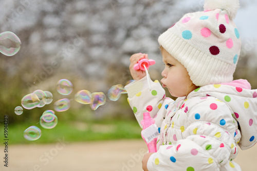 Photo: toddler girl blowing soap bubbles toddler girl blowing soap bubbles