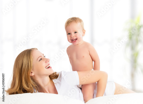 Photo: happy family mother and baby in bed happy family mother and baby in bed