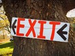 Exit Sign in White Red and Black on Tree Exit Sign in White Red and Black on Tree