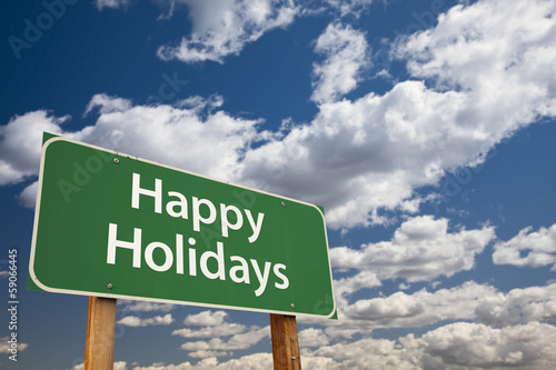 Photo: Happy Holidays Green Road Sign Over Clouds and Sky Happy Holidays Green Road Sign Over Clouds and Sky