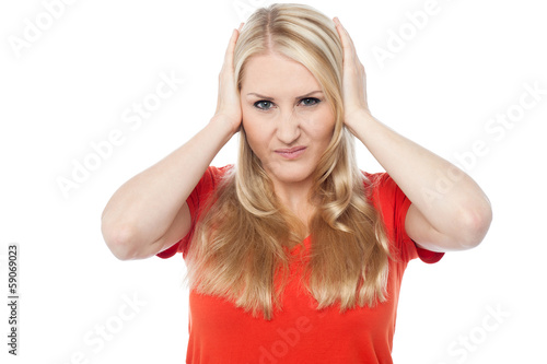 Photo: Young woman covering her ears Young woman covering her ears