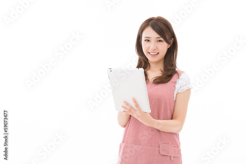 Photo: タブレットを見ながら料理をする女性 タブレットを見ながら料理をする女性