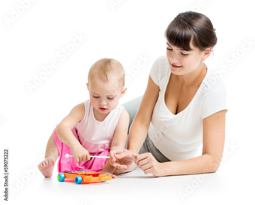 Photo: Mother and baby play musical toy isolated on white background Mother and baby play musical toy isolated on white background