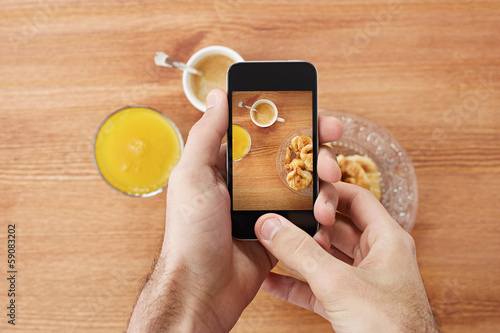 Photo: Hands taking photo of breakfast with smartphone Hands taking photo of breakfast with smartphone