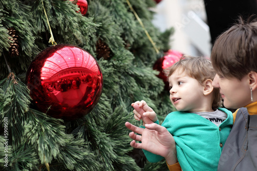 Photo: Child with mother at christmas tree Child with mother at christmas tree