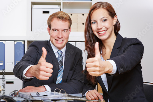 Photo: Two business people holding thumbs up Two business people holding thumbs up