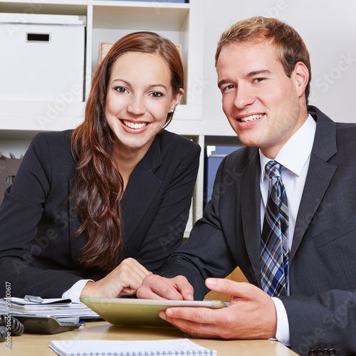 Photo: Two happy business people in office Two happy business people in office