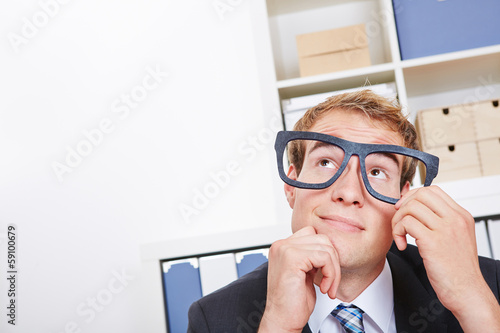 Photo: Pensive business man in office with nerd glasses Pensive business man in office with nerd glasses