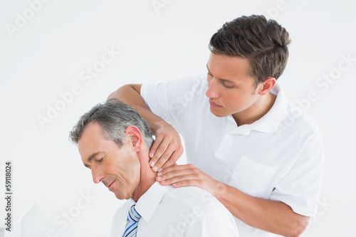 Photo: Male chiropractor massaging patients neck Male chiropractor massaging patients neck