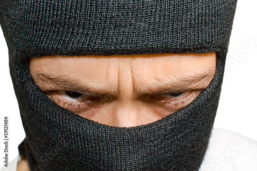 Photo: Close-up shot of angry man in black mask Close-up shot of angry man in black mask