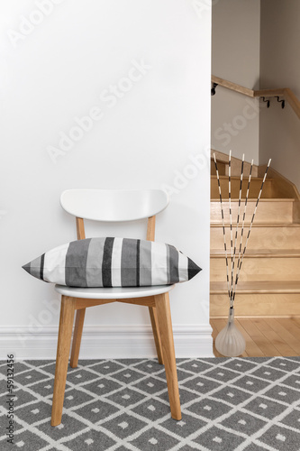 Photo: Chair with cushion in a room with staircase Chair with cushion in a room with staircase