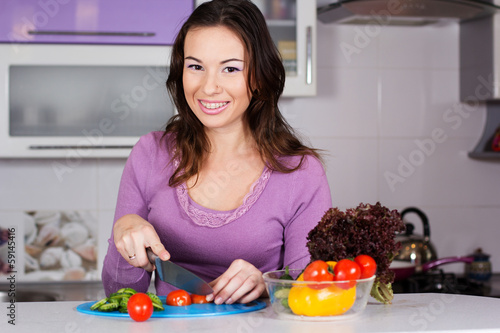 Photo: Pretty woman cooking food in the kitchen Pretty woman cooking food in the kitchen