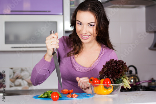 Photo: Pretty woman cooking food in the kitchen Pretty woman cooking food in the kitchen