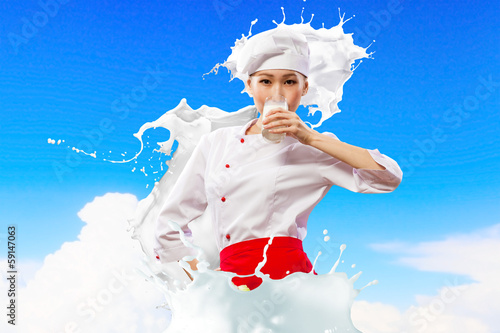 Photo: Asian female cook against milk splashes Asian female cook against milk splashes