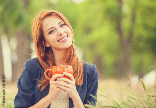 Photo: Redhead girl with orange cup at outdoor Redhead girl with orange cup at outdoor