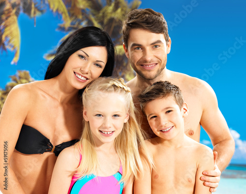 Photo: Happy family with two children at tropical beach Happy family with two children at tropical beach