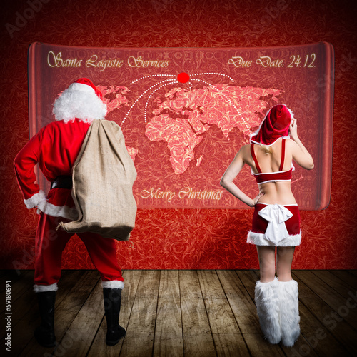 Photo: Santa und Miss Santa vor Weltkarte Santa und Miss Santa vor Weltkarte