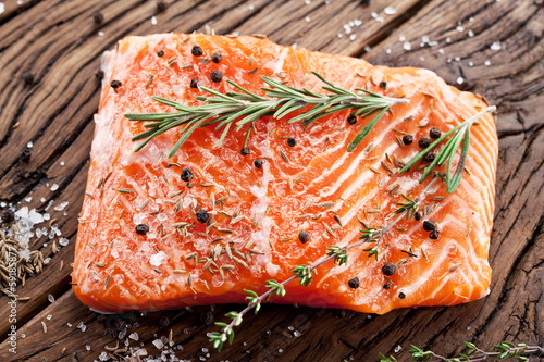 Photo: Salmon filet on a wooden carving board. Salmon filet on a wooden carving board.