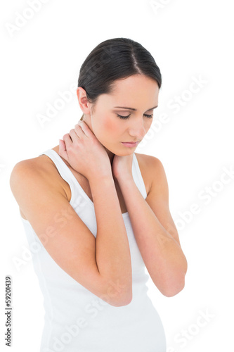Photo: Serious casual woman suffering from neck ache Serious casual woman suffering from neck ache
