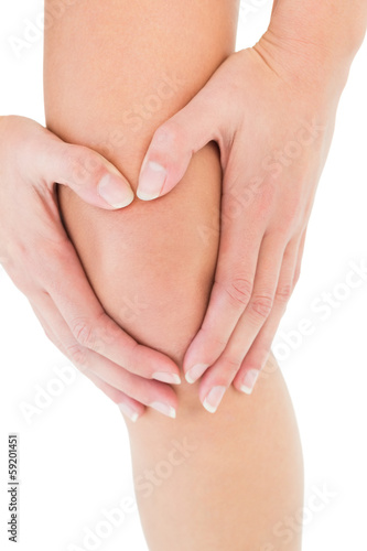 Photo: Close-up mid section of a young woman with knee pain Close-up mid section of a young woman with knee pain
