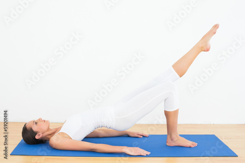 Photo: Fit woman doing pilate exercises in the fitness studio Fit woman doing pilate exercises in the fitness studio