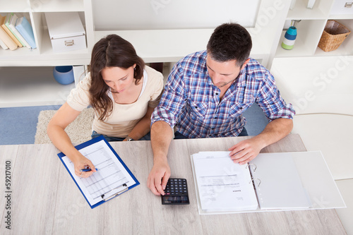 Photo: Couple Calculating Bills Couple Calculating Bills