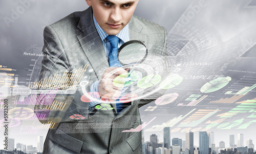 Photo: Man looking in magnifier Man looking in magnifier
