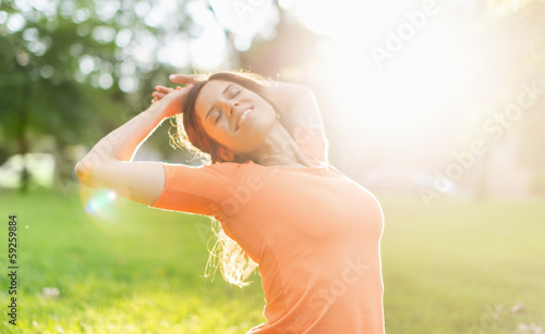 Photo: Beautiful woman enjoying the light of a summer sunset Beautiful woman enjoying the light of a summer sunset