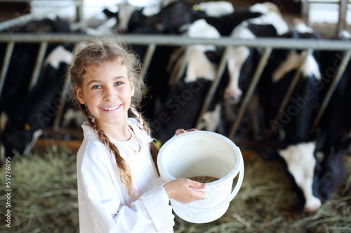Photo: Little beautiful girl holds white bucket with food and smiles in Little beautiful girl holds white bucket with food and smiles in