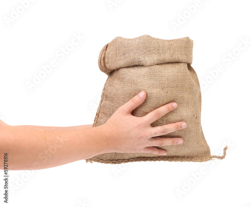 Photo: Hand holds bag of money. Hand holds bag of money.
