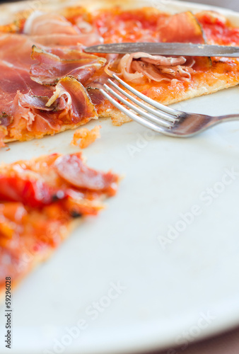 Photo: Closeup view of half pizza on a plate Closeup view of half pizza on a plate