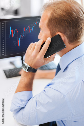 Photo: businessman with smartphone in office businessman with smartphone in office
