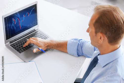 Photo: businessman working with forex chart in office businessman working with forex chart in office