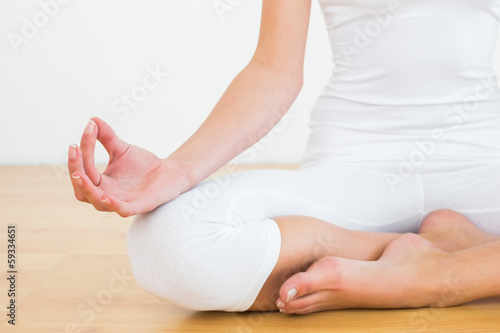 Photo: Close-up of woman in lotus pose at fitness studio Close-up of woman in lotus pose at fitness studio
