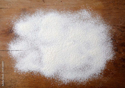 Photo: white flour on wooden table white flour on wooden table