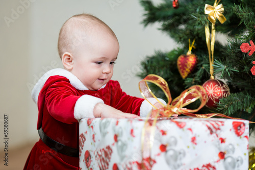 Photo: baby in front of Christmas tree with big gift box baby in front of Christmas tree with big gift box