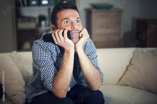 Photo: Smiling man watching interesting movie Smiling man watching interesting movie